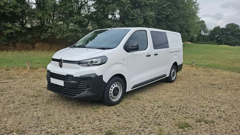 Fourgon utilitaire blanc garé sur du gravier